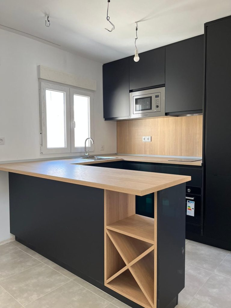 Cocina con puertas en Zenith negro con encimera y emplacado en Formica.