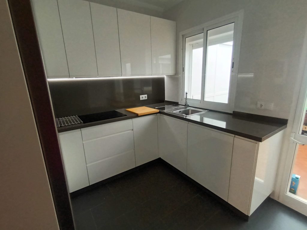 Cocina con puertas Finger-Pull Blanco Brillo y encimera Silestone Mod. Cemento Spa