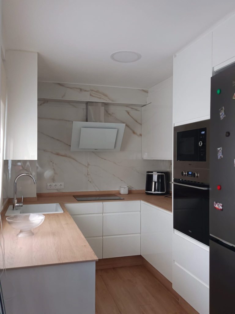 cocina con puerta fingerpull blanco brillo y encimera fenolica rovere